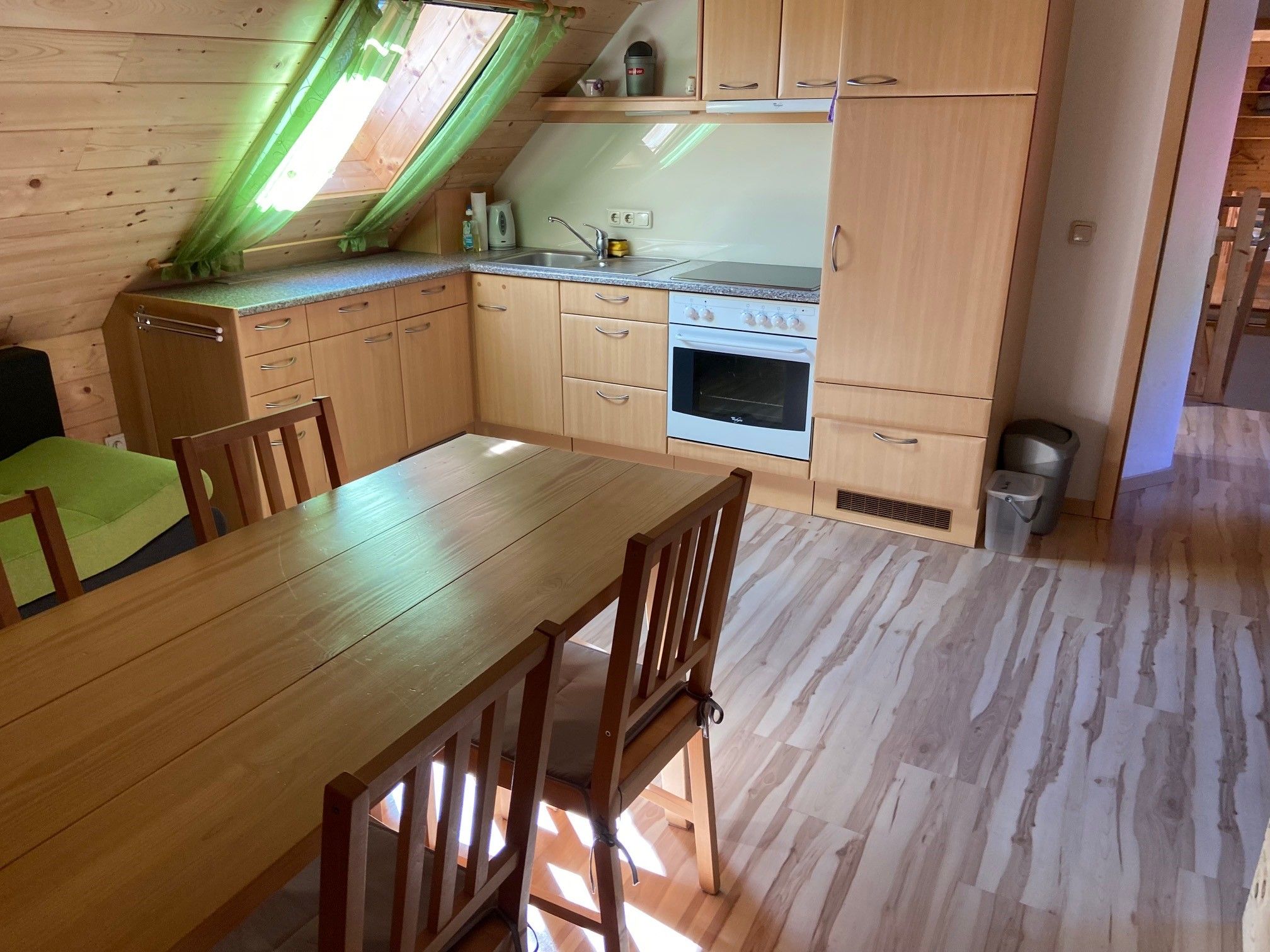 Kitchen in a vacation apartment with wooden furniture and skylight.