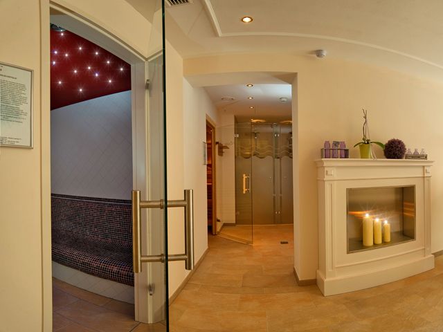 An elegant wellness area with fireplace, candles and sauna.