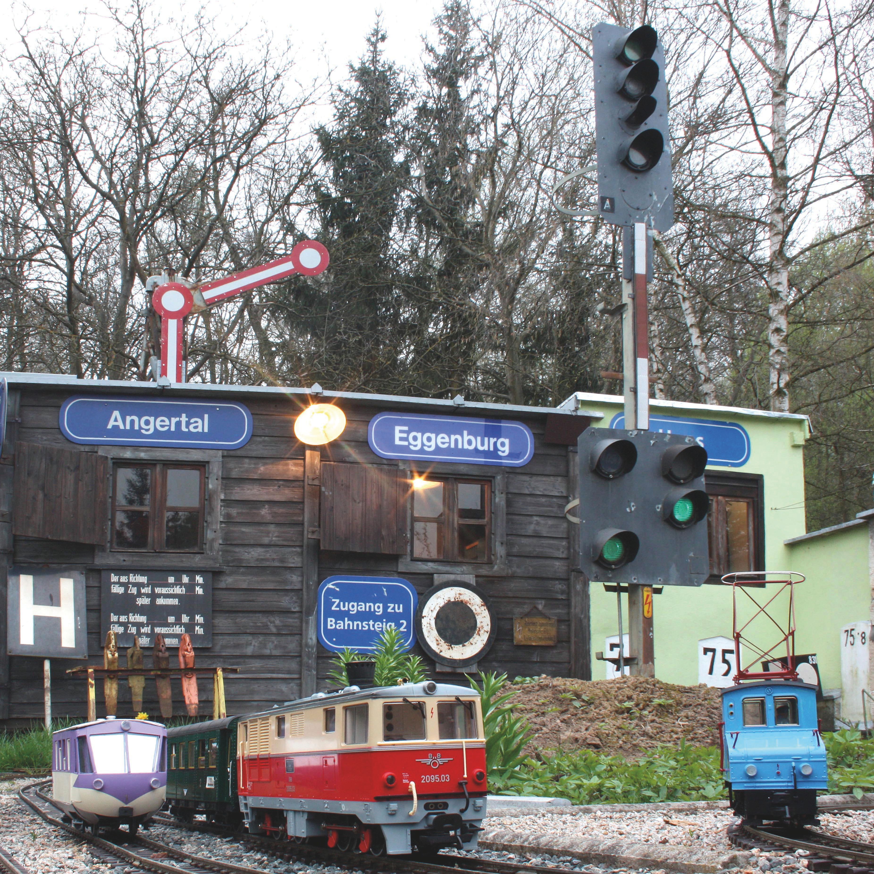 Model railroad with trains in front of a small building with signs 'Angertal' and 'Eggenburg'.