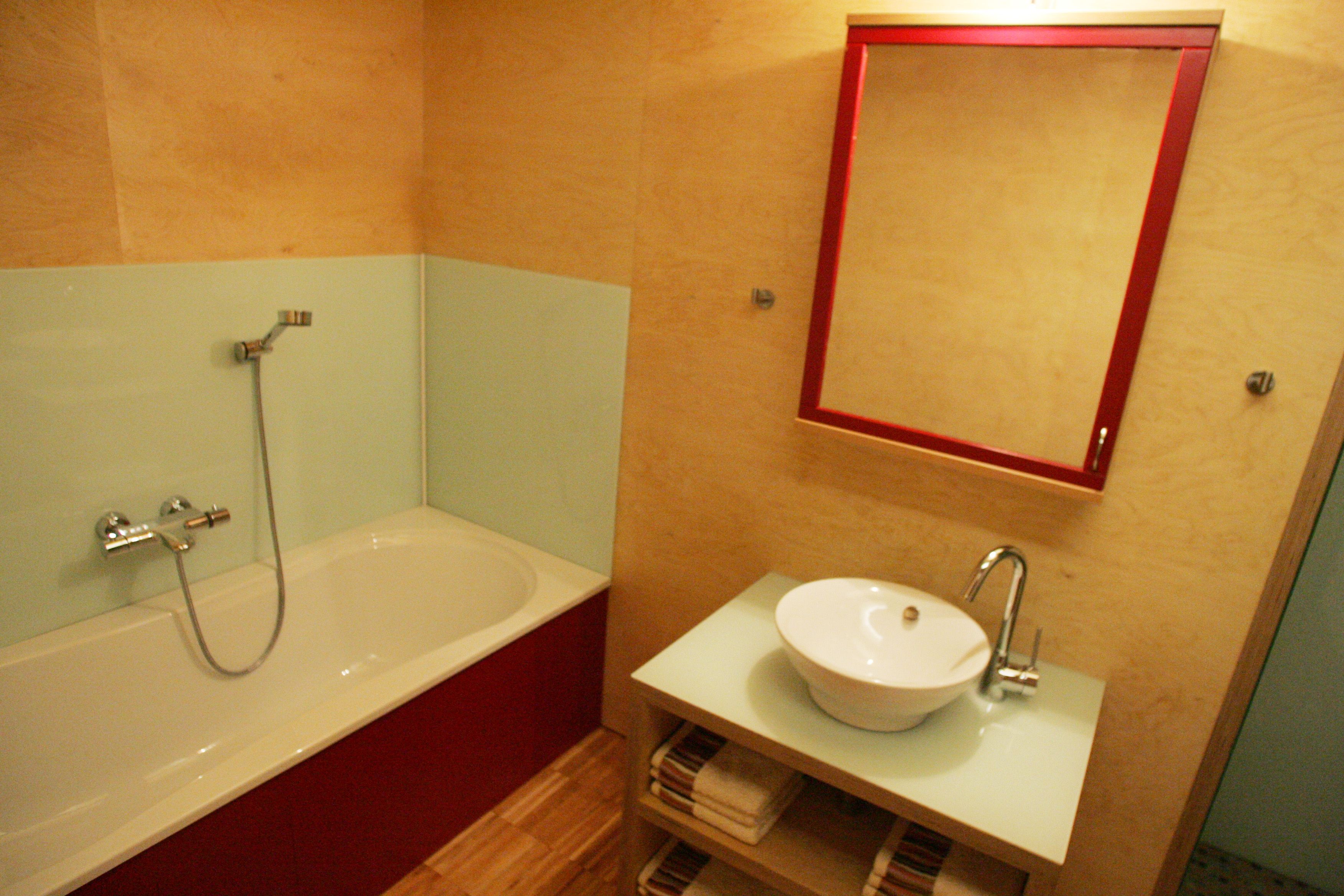 Modern bathroom with bathtub, washbasin and mirror.