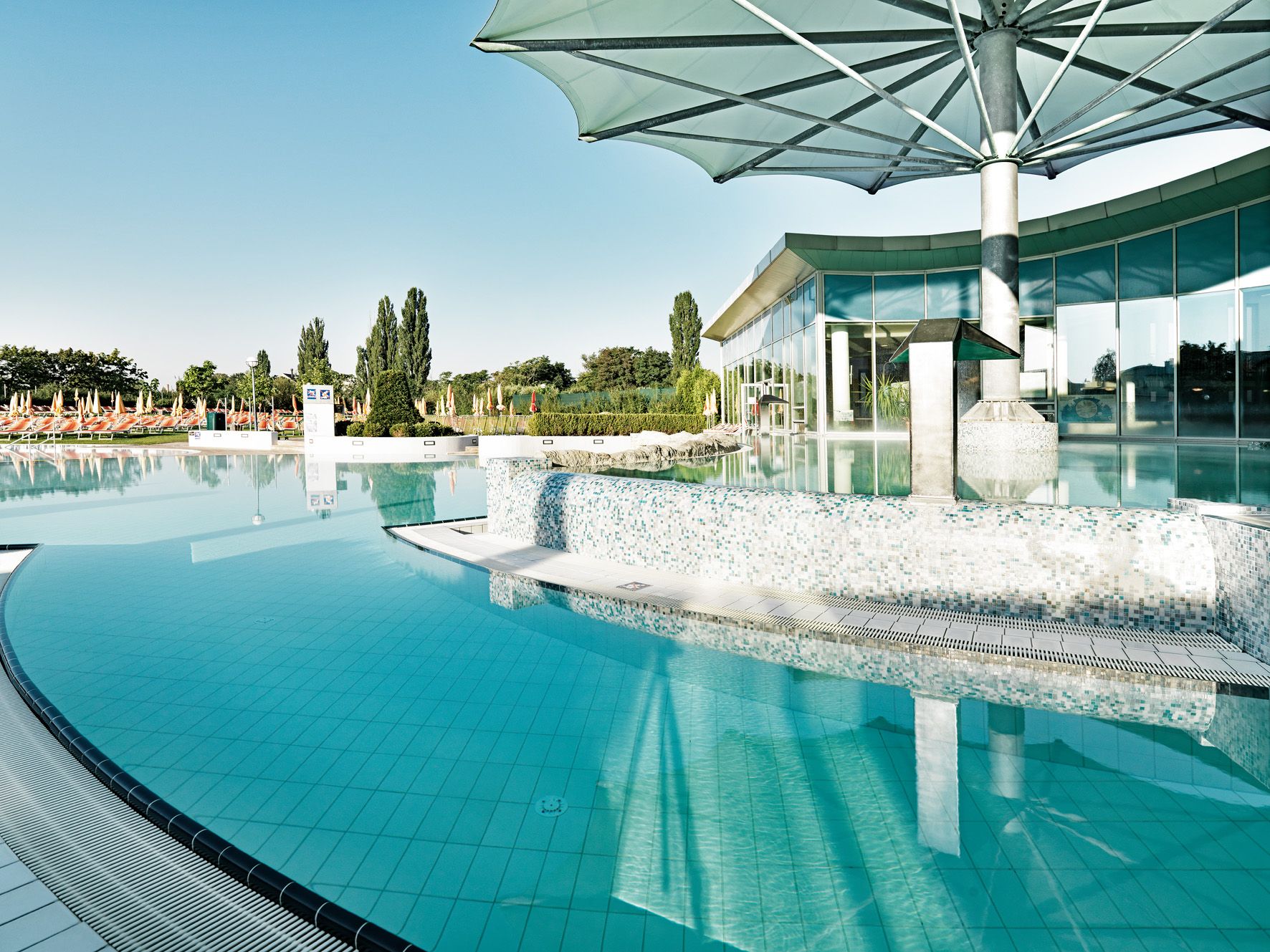 Outdoor area of Therme Laa with pool and sunshades.
