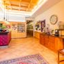 Reception area with wooden furniture, red counter, decorative plates on the wall and a clock.