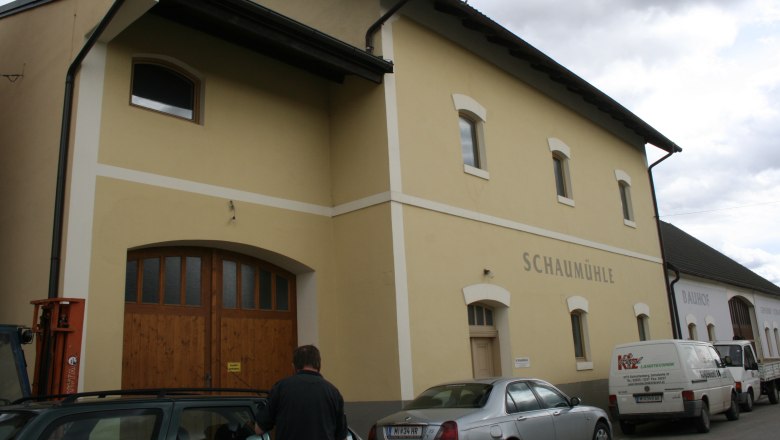 Exterior view of a yellow building with the inscription 'Schaum&uuml;hle'.
