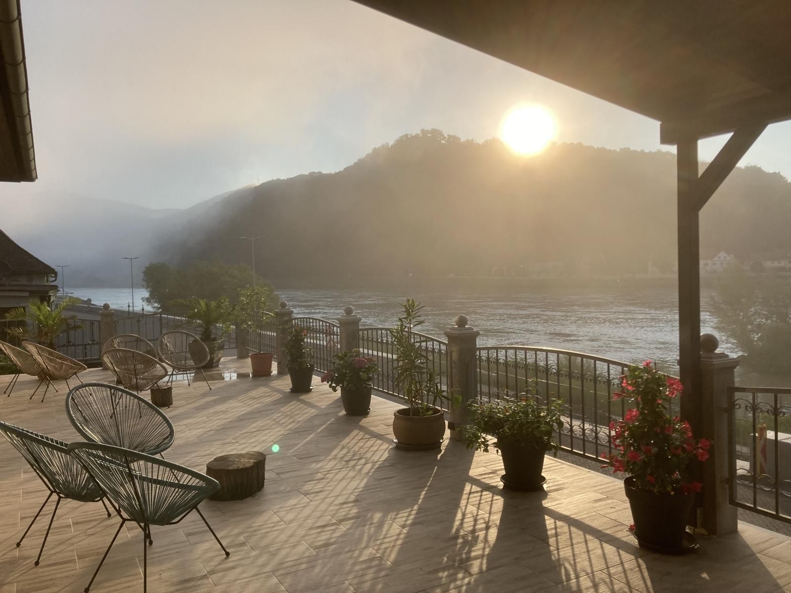 Terrace with a view of the river and mountains at sunrise.
