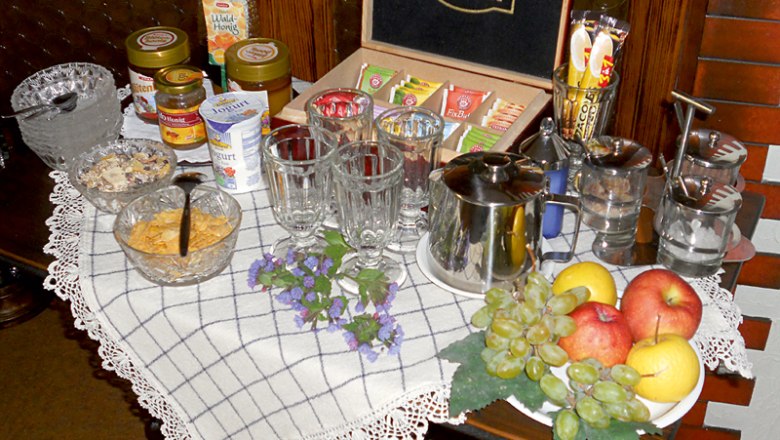 Frühstücksbuffet mit verschiedenem Tee, Obst und Aufstrichen.