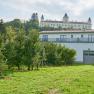 Wolfsberg Castle in the background with orchard in the foreground.