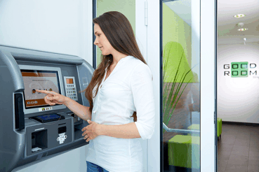 Woman operating a check-in machine in a modern reception area.