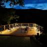 Illuminated terrace with chairs and tables at night.