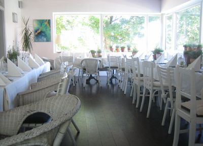 A bright conservatory with white furniture and large windows.