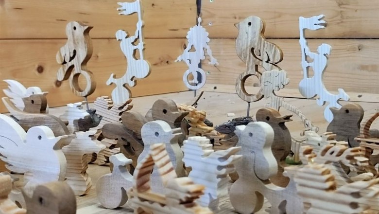 Wooden figures in animal and human form on a wooden table.