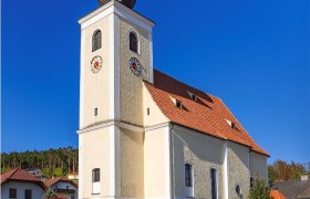 Hollenthon parish church with onion dome and blue sky.