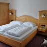 Comfort room with double bed and solid wood furniture.