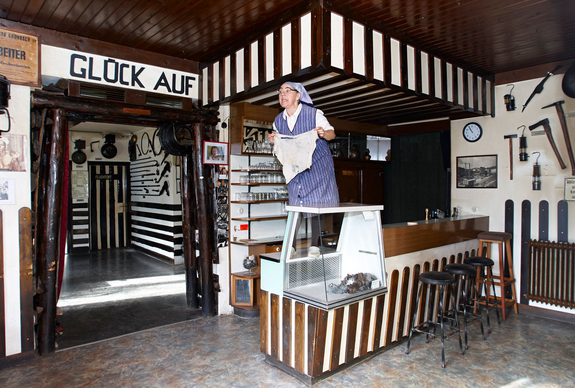 Interior view of the Grünbach Mining Museum with a person in traditional clothing standing on a counter.