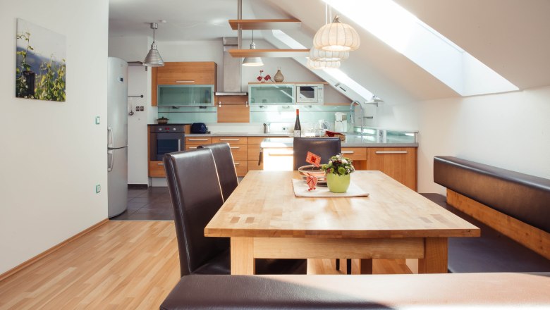 Apartment at Bioweingut Jakob, © Bioweingut Jakob Modern kitchen with wooden furniture and dining table in an apartment.