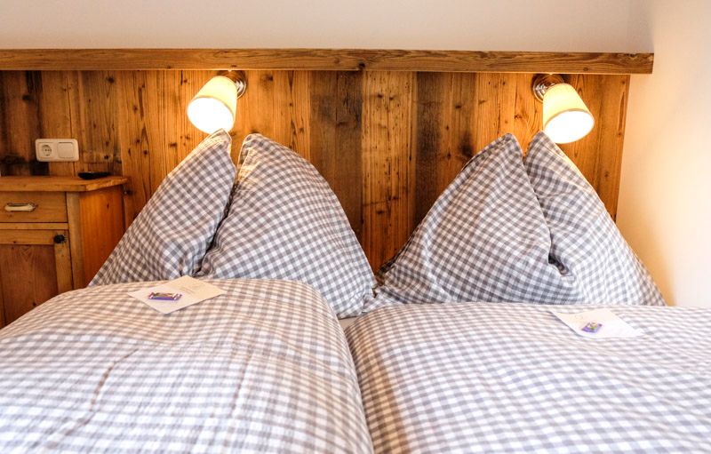 Cozy bedroom with checkered bedspreads and wood paneling.