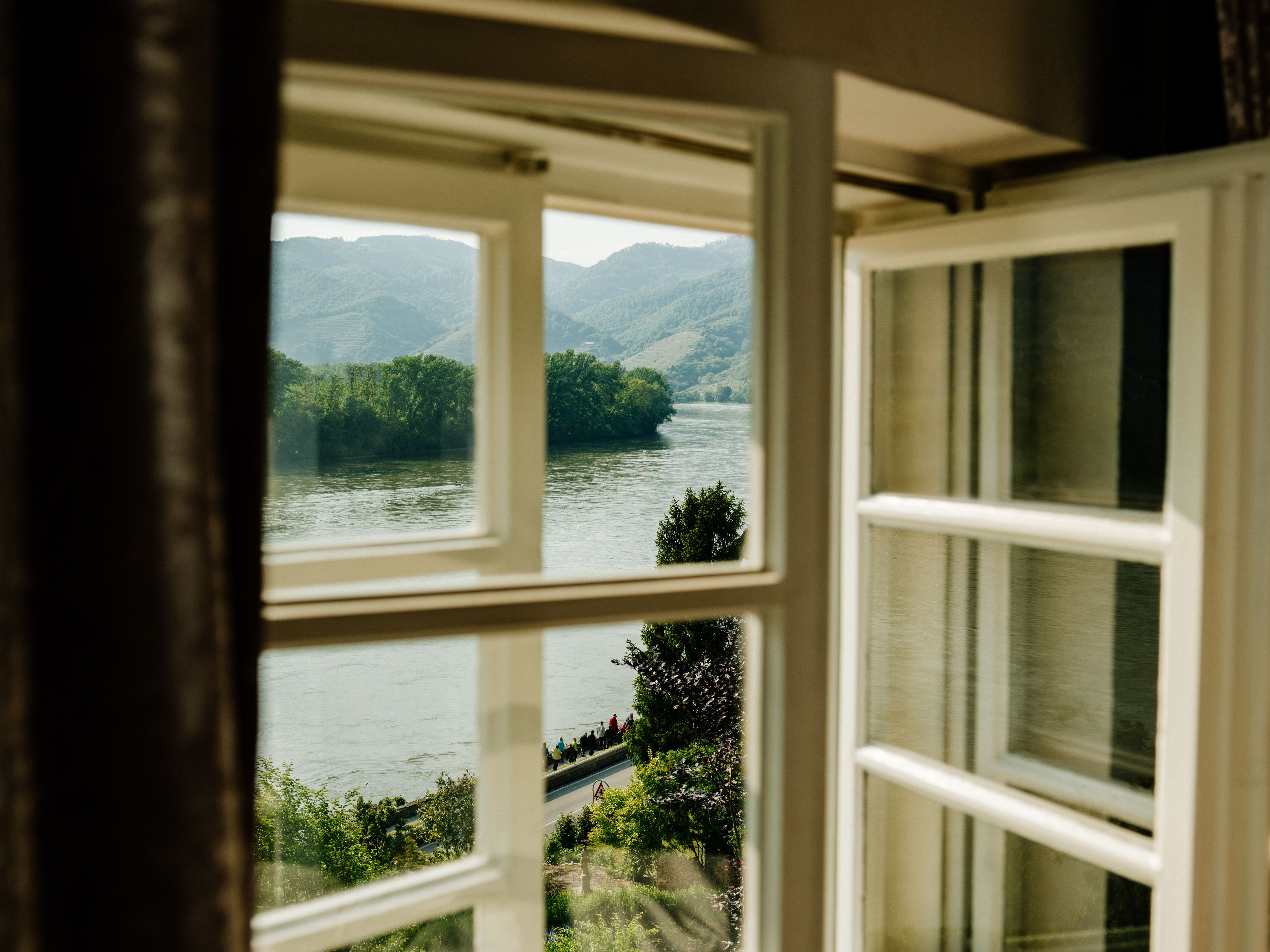 View from a window of a river and wooded hills.