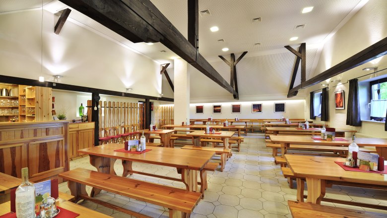 Interior view of a winery with wooden tables and benches.