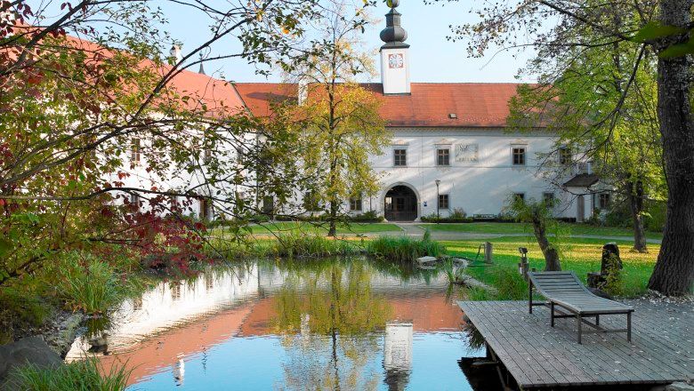 Inner courtyard of Schiltern Castle with pond and sun lounger.