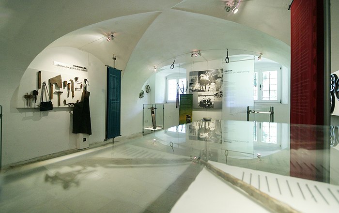 Interior view of a museum with tools and historical photos.
