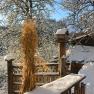 Snowy landscape with a wooden fence and a birdhouse.