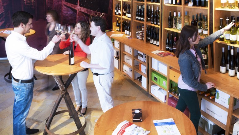 People in a wine store tasting wine and selecting bottles.