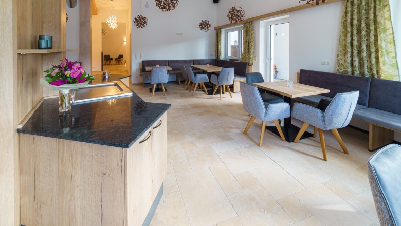 Interior view of a modern caf&eacute; with wooden furniture and flower arrangements.