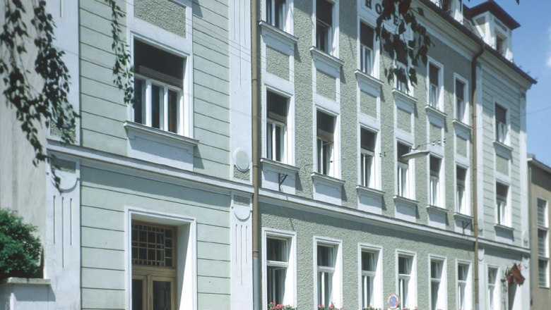 Exterior view, © Zauza Exterior view of a multi-storey building with a green façade and white window frames.