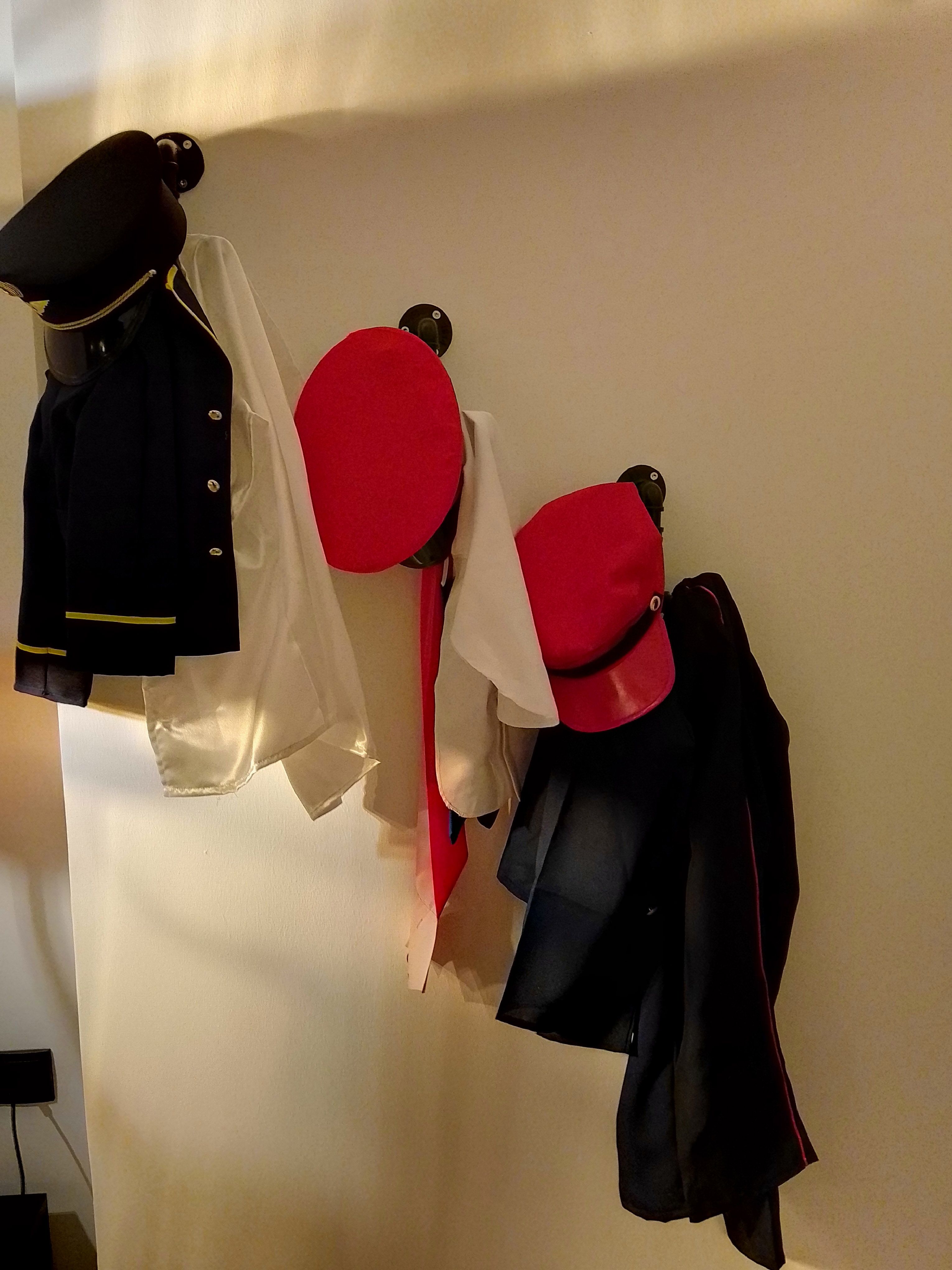 Uniform parts and caps hung on a wall.