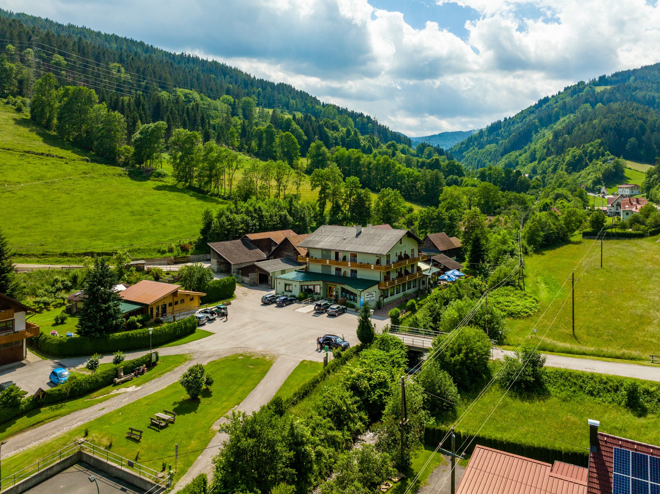 Rural landscape with a large building surrounded by green hills and trees.