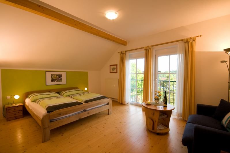 Comfortable bedroom with double bed, wooden furniture and balcony access.