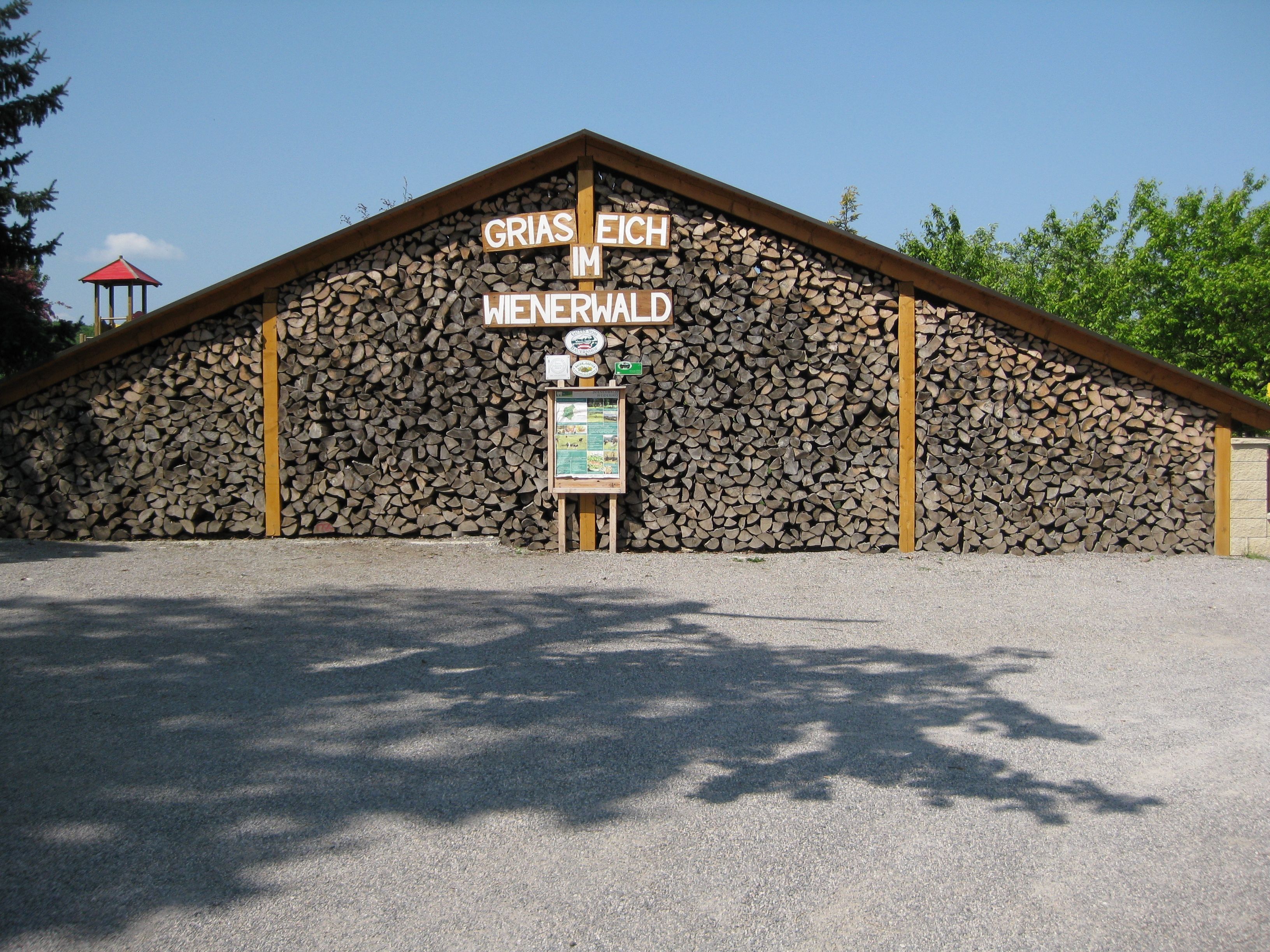 Woodpile with sign 'Griaß Eich im Wienerwald'.
