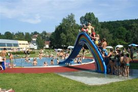 Children play on a colorful slide in the outdoor pool.
