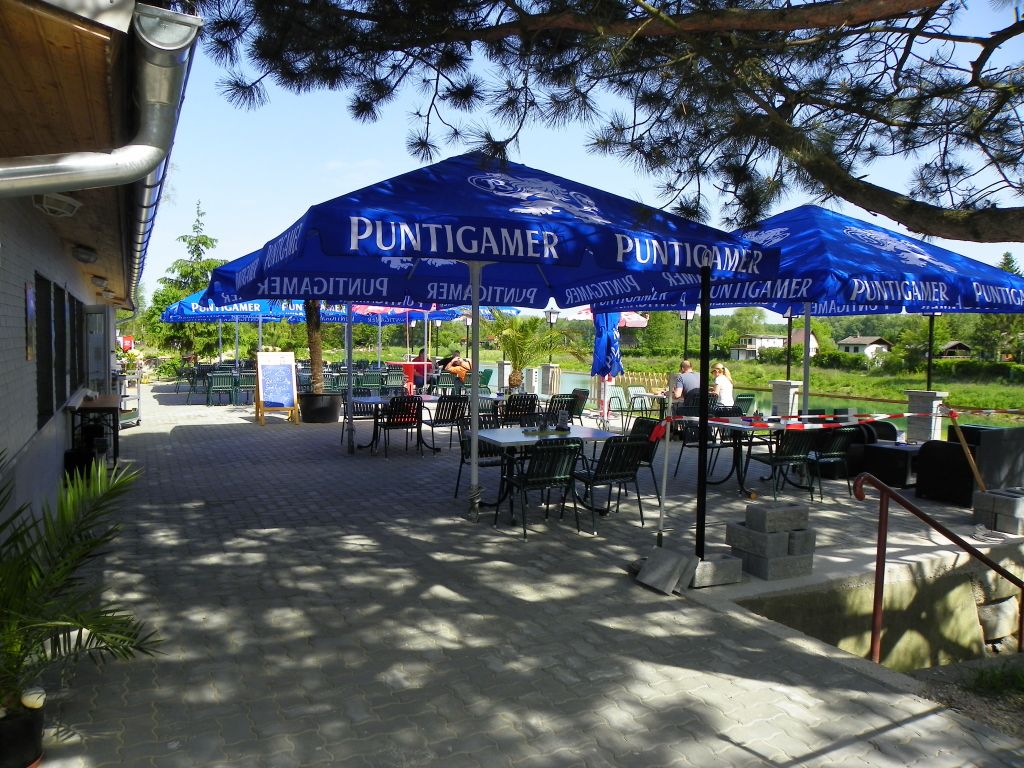 Outdoor area of a restaurant with blue parasols and tables.