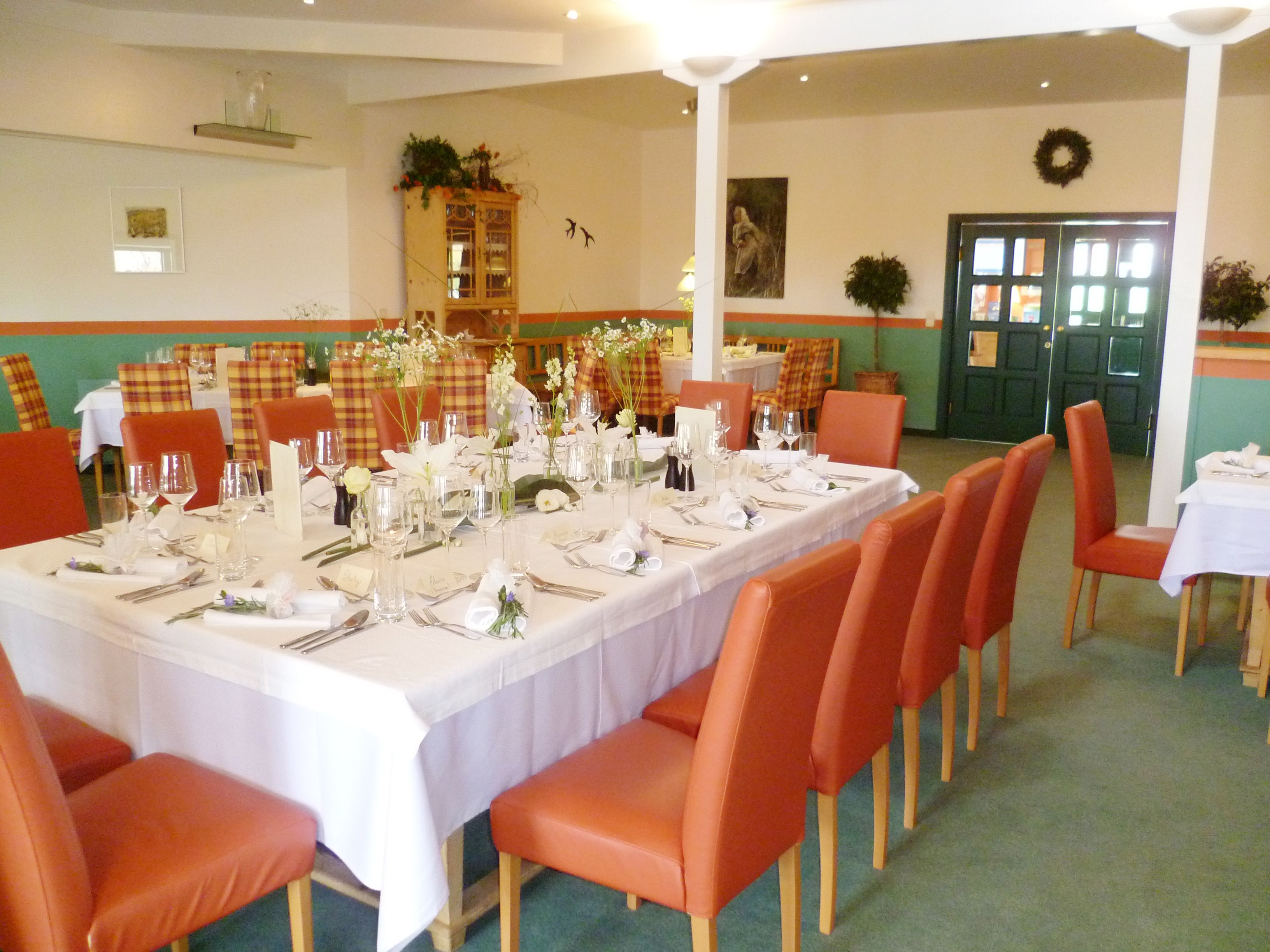 Elegant restaurant with laid table and red chairs.