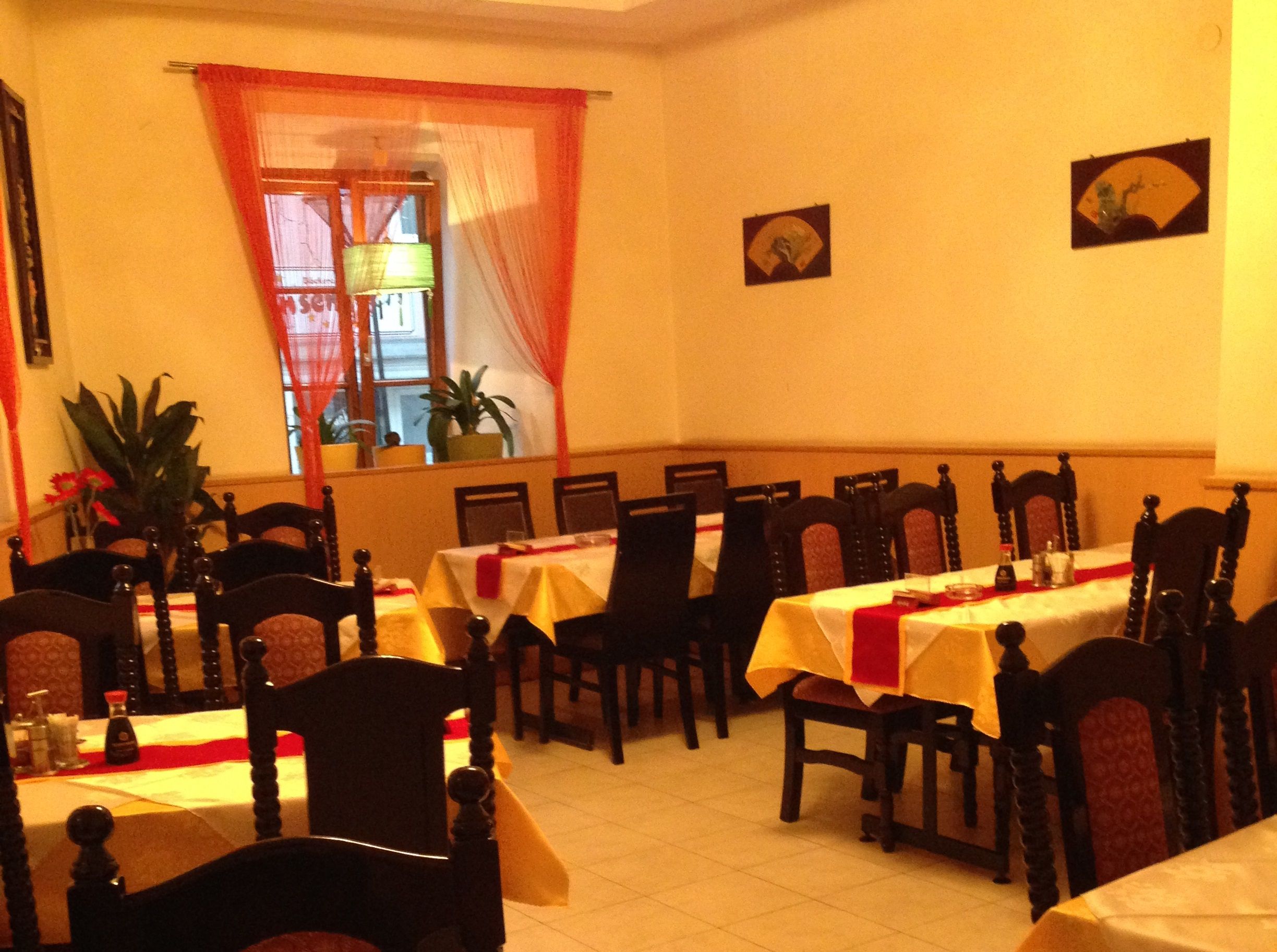 Interior view of an Asian restaurant with set tables and chairs.