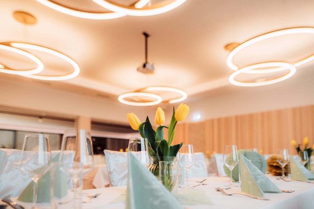 Elegant dining room with modern lighting and table decorations with yellow tulips.