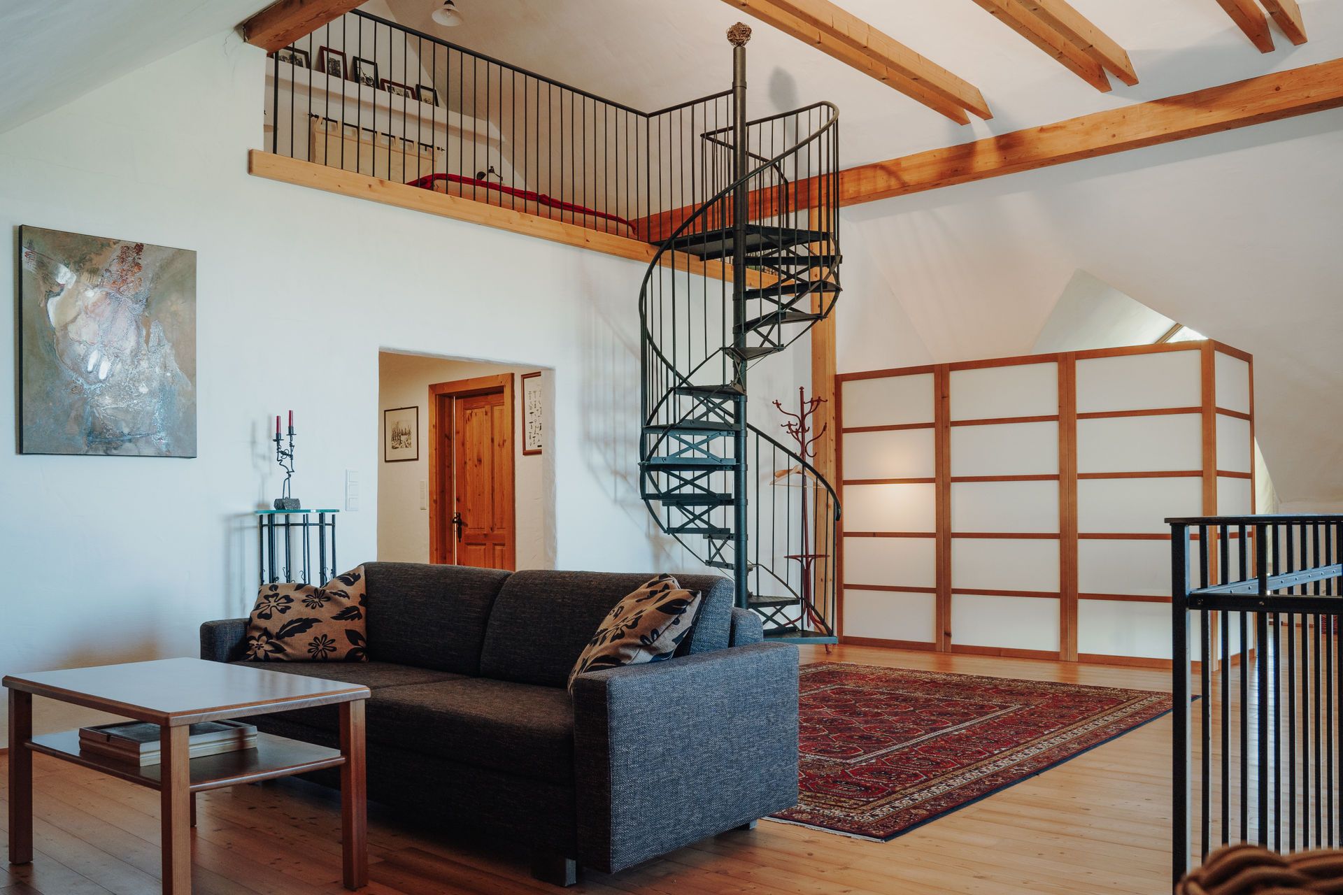 Spiral staircase up to the sleeping area, cozy couch in the foreground