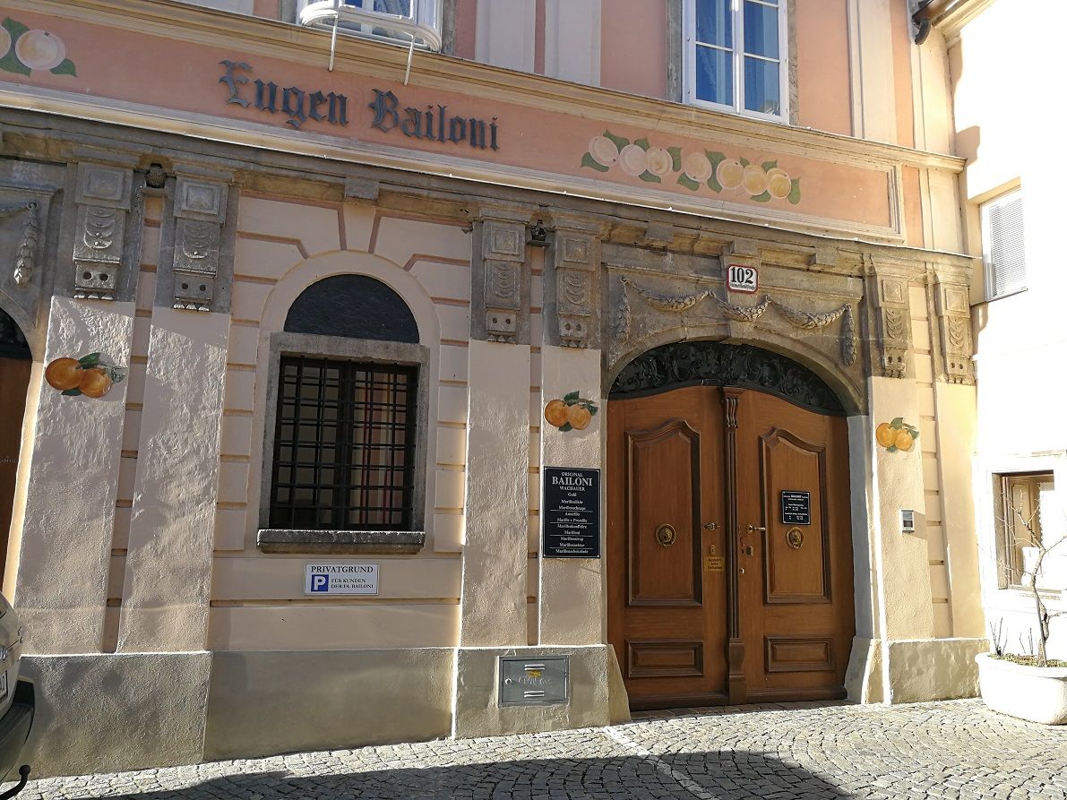 Historic façade with wooden door and 'Eugen Bailoni' lettering.