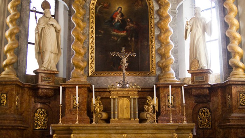 Altar in a church with golden decorations and paintings.