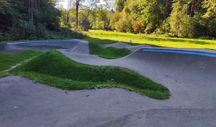 Pump track in Bad Sch&ouml;nau with green surroundings and trees in the background.