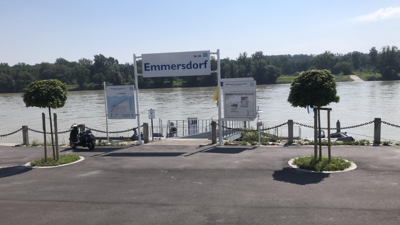 Emmersdorf landing stage on the Danube with signs and trees.
