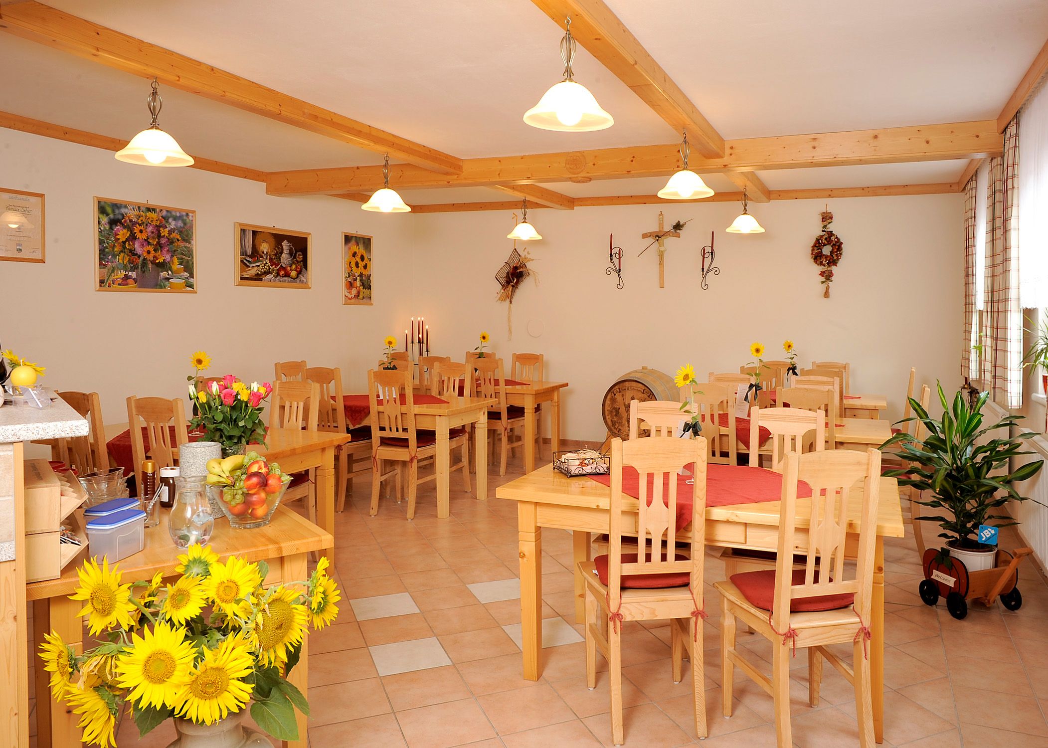 A cozy breakfast room with wooden furniture, sunflowers and decorations on the walls.