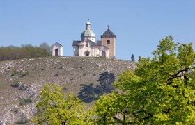 Church on a hill with trees in the foreground.