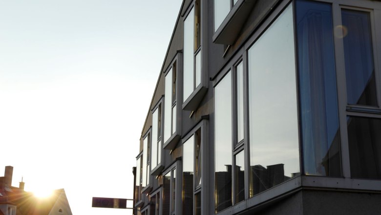 Modern building façade with large windows in the sunset.