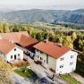 Aerial view of a farm with red roofs in a hilly landscape.
