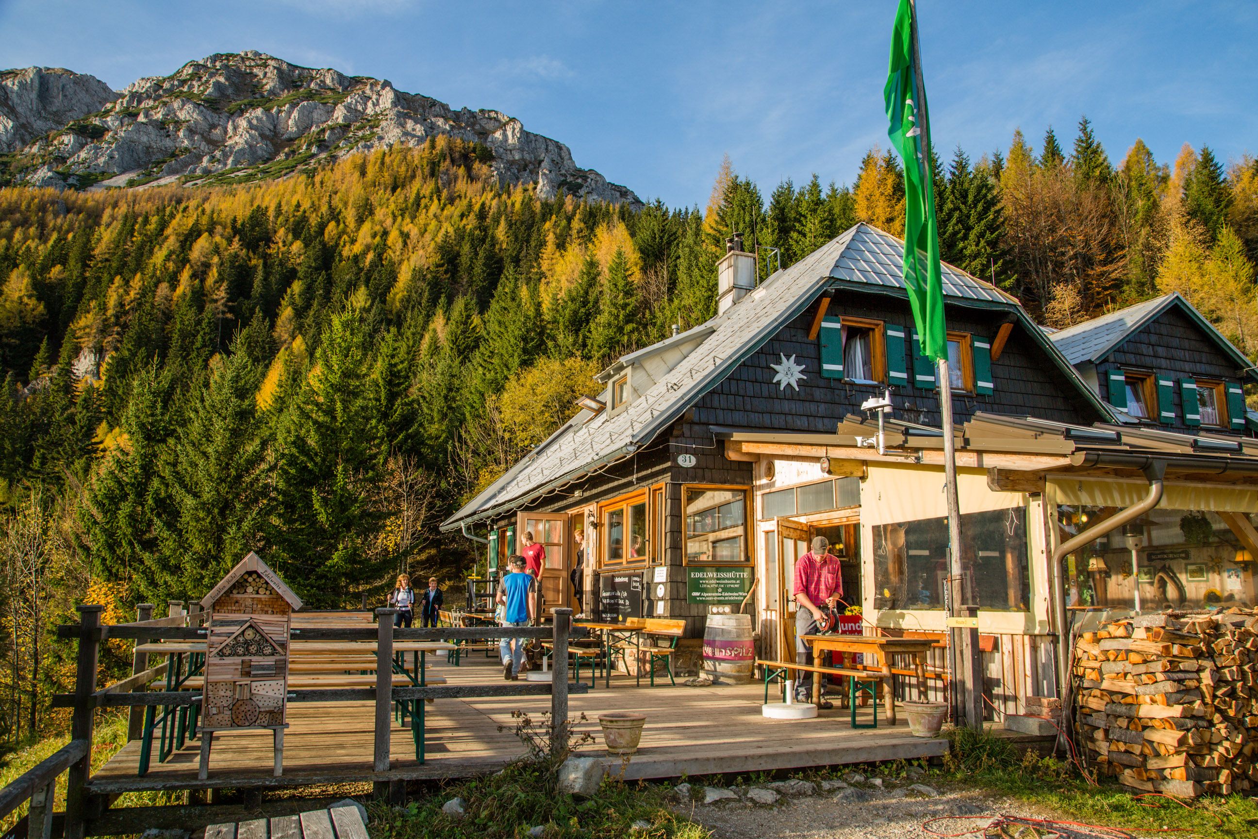 Edelweiss hut on Schneeberg with mountain scenery and forest in the background.