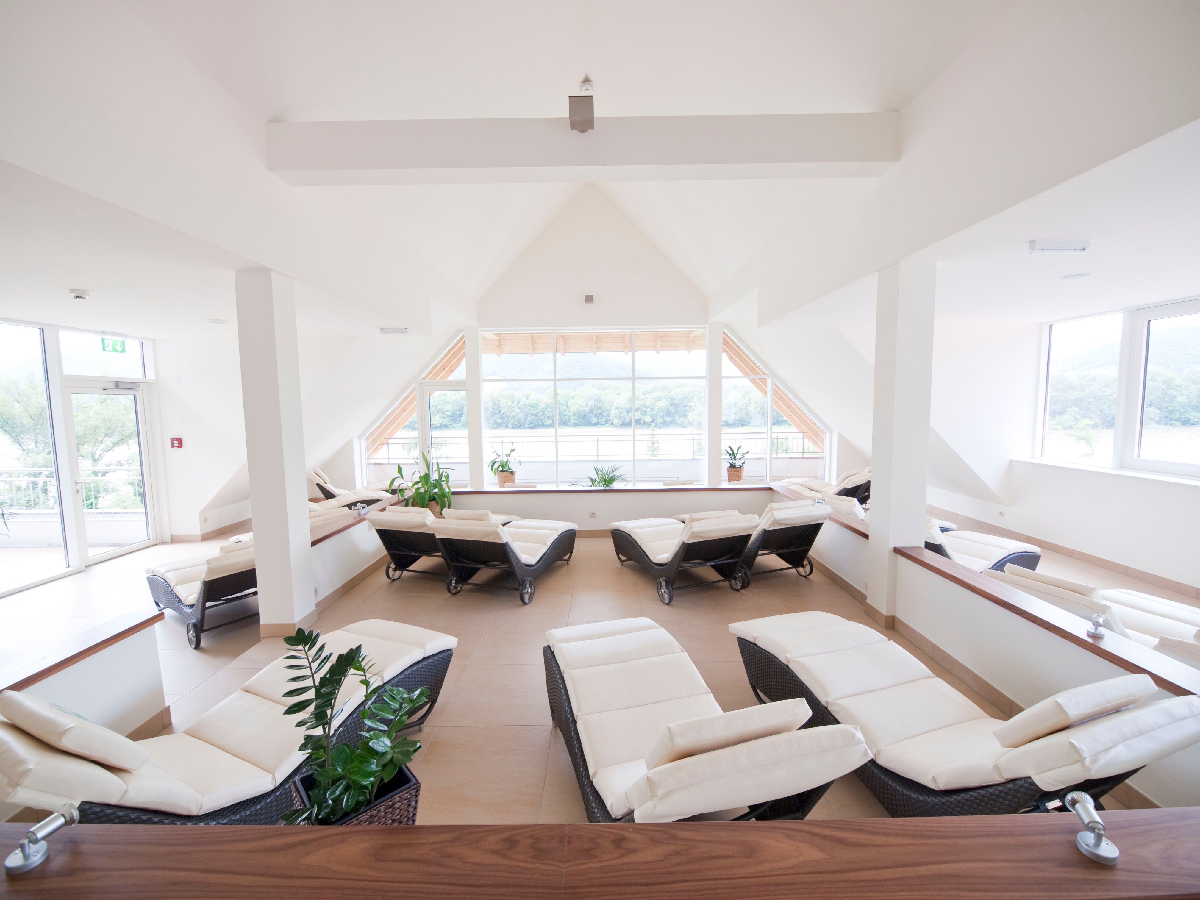 Bright spa room with loungers and large windows.