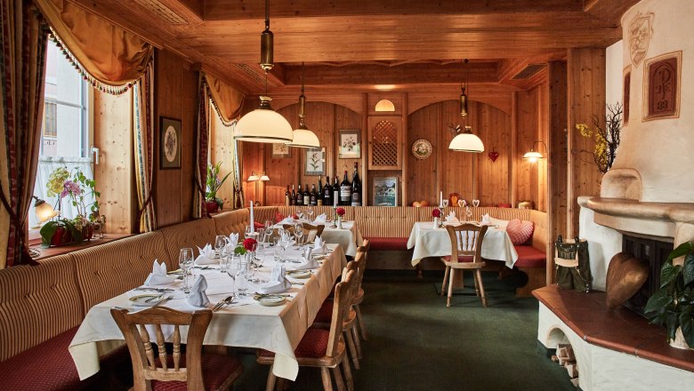 Cozy restaurant with wooden walls, covered tables and fireplace.