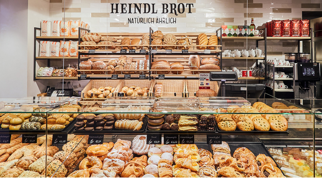 Bakery with various breads and pastries on shelves and in display cases.