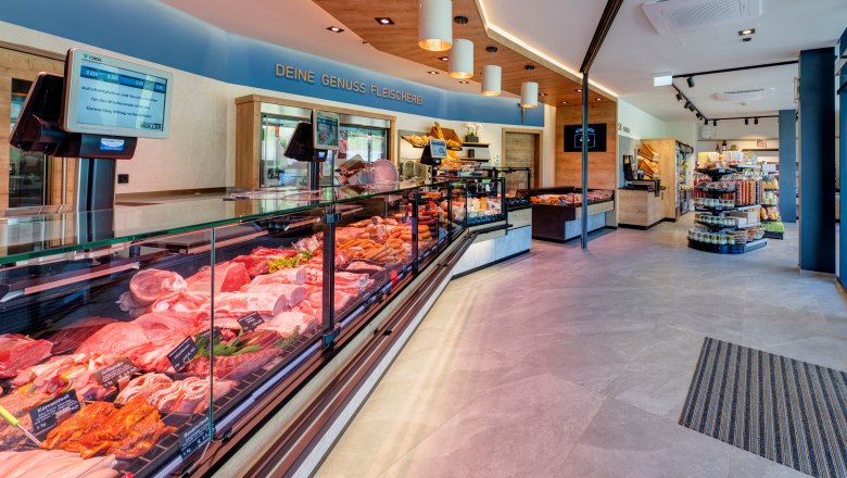 Sales room of a butcher's shop with showcases with meat and sausage products and shelves.